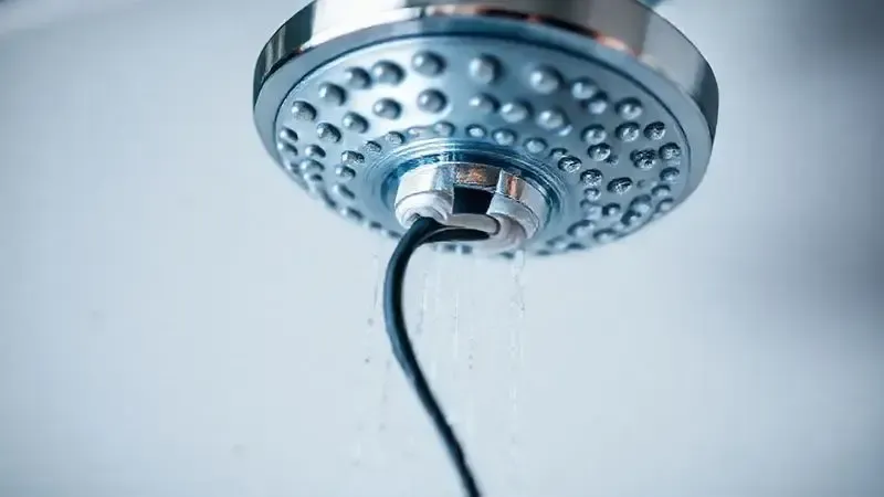 Detalhe da instalação elétrica segura de uma ducha, com fiação devidamente isolada e conectada, representando a importância da segurança do produto.